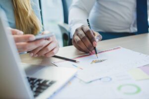 Professionnels analysant des données marketing avec graphiques colorés lors d'une réunion de travail collaborative